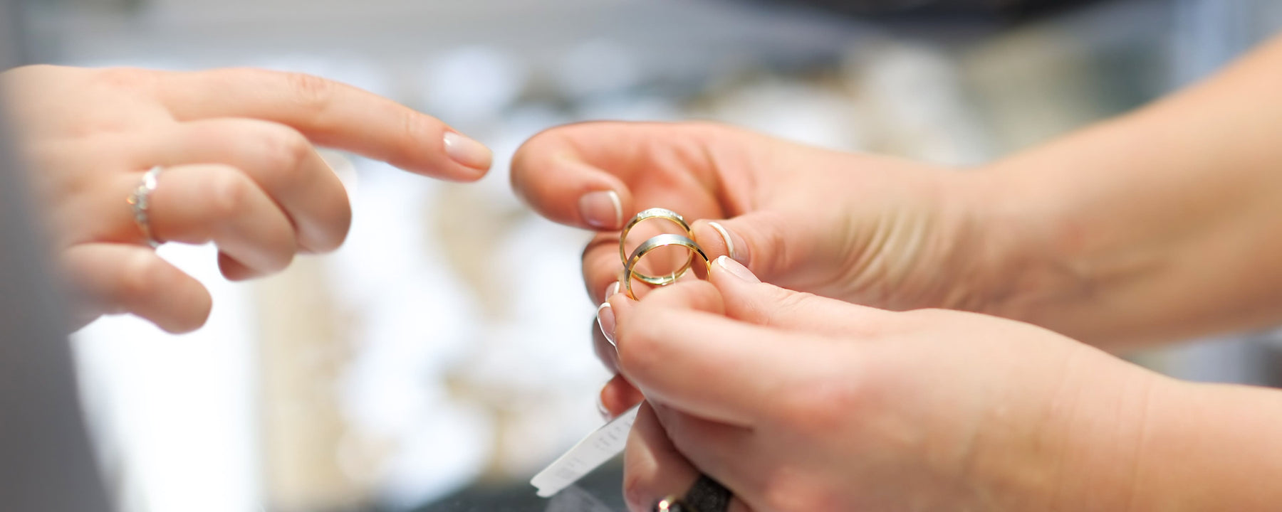 An associate presents two rings while a customer points to one